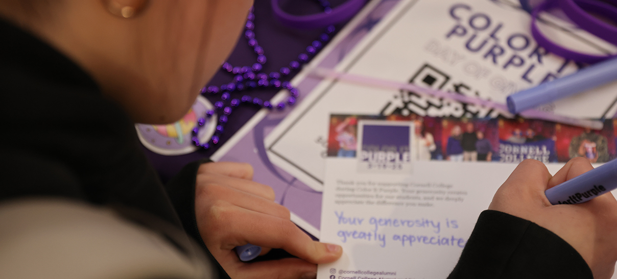 Current Cornell student writing a thank you note to a donor after Color It Purple